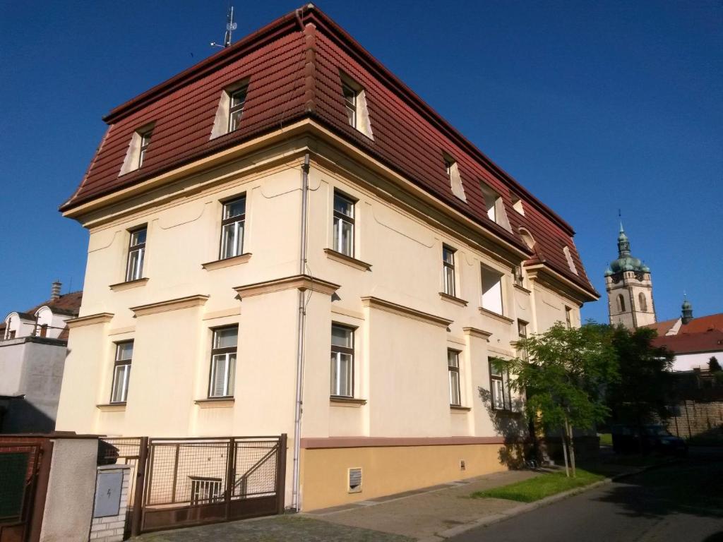 un gran edificio blanco con techo rojo en Hotel Jaro, en Mělník