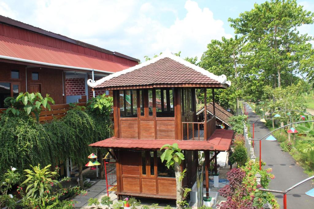een prieel in een tuin naast een gebouw bij Georium Dunia in Prambanan