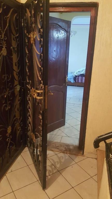 an open wooden door in a room with a tile floor at Apparemment mohammedia in Mohammedia