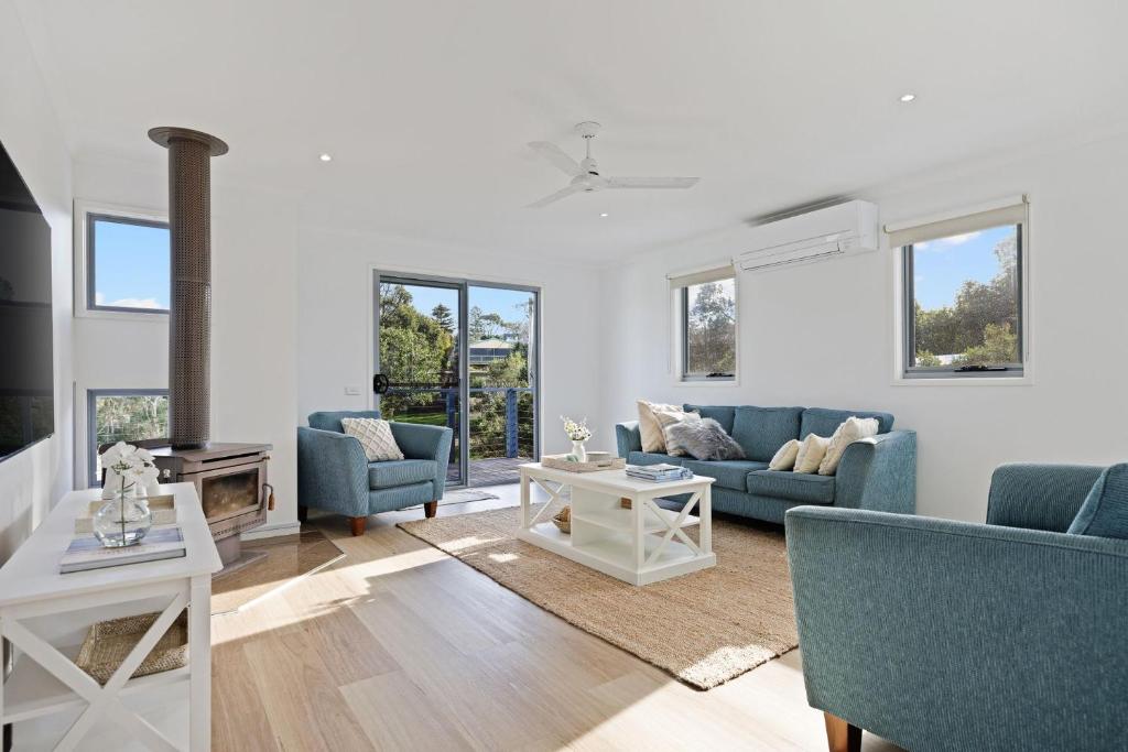a living room with blue couches and a fireplace at Island Court in Smiths Beach