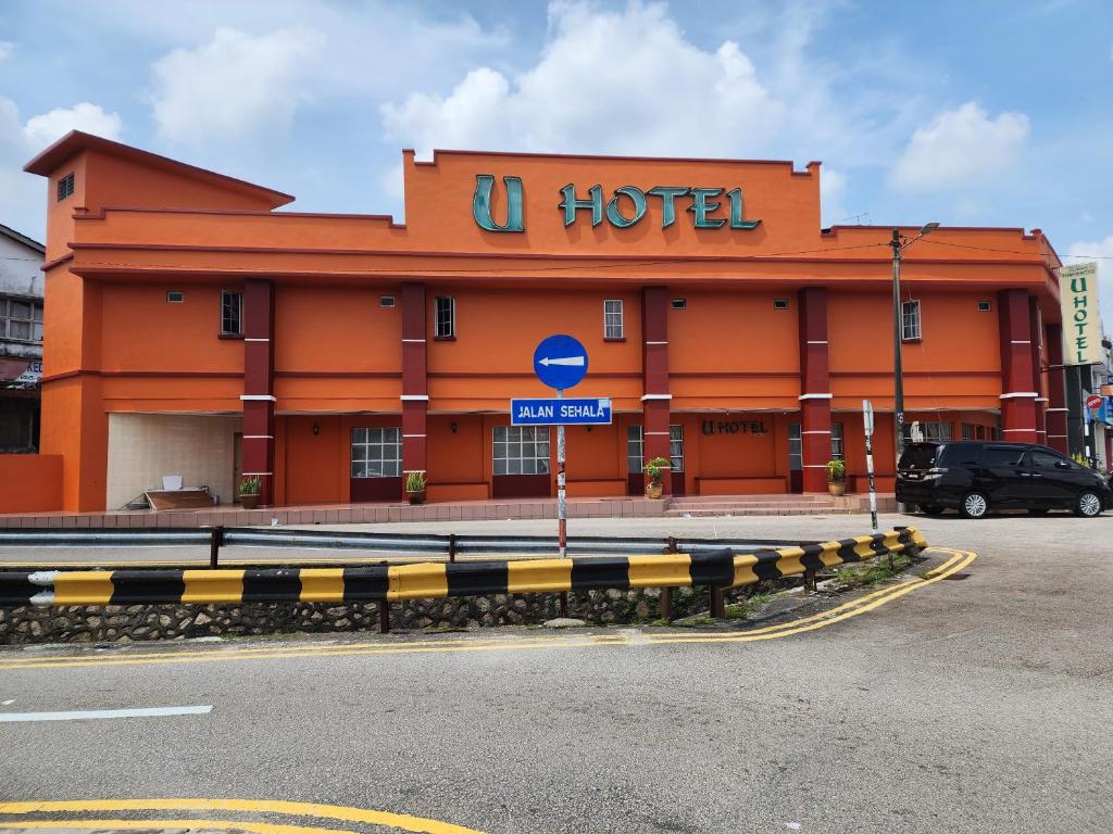 an orange hotel with a sign in front of it at U HOTEL in Skudai