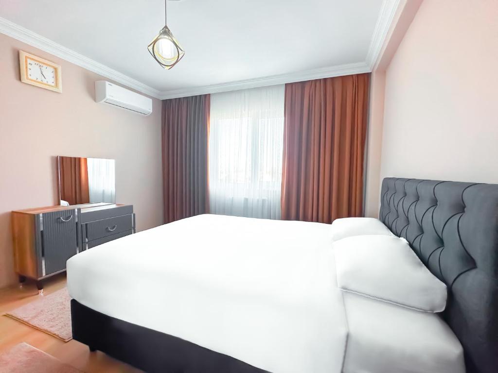 Grand Crown Suites - شقق غراند كراون السياحية في طرابزون: غرفة نوم بسرير ابيض واريكة