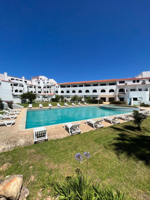 a resort with a swimming pool and lounge chairs at Retiro do Sossego in Sagres