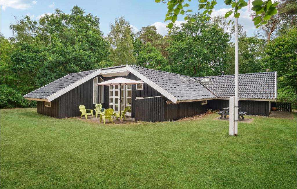 a black shed with a table and chairs in a yard at Lovely Home In Sklskr With Kitchen in Skælskør