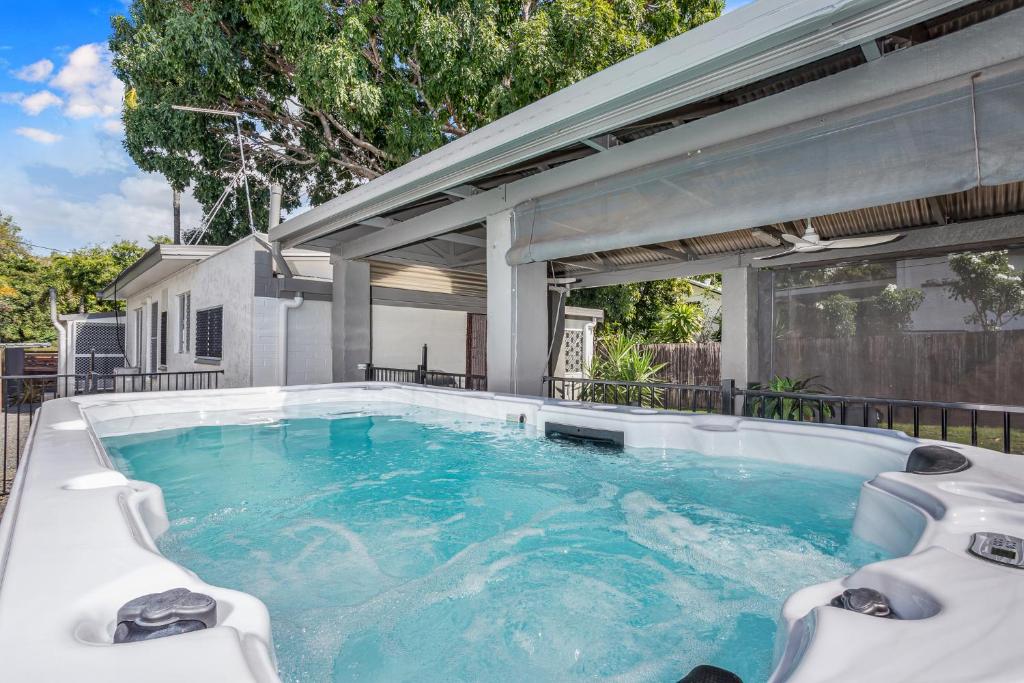 una piscina en un patio trasero con una casa en Seaside Serenity Modern Cottage with Spa, en Machans Beach