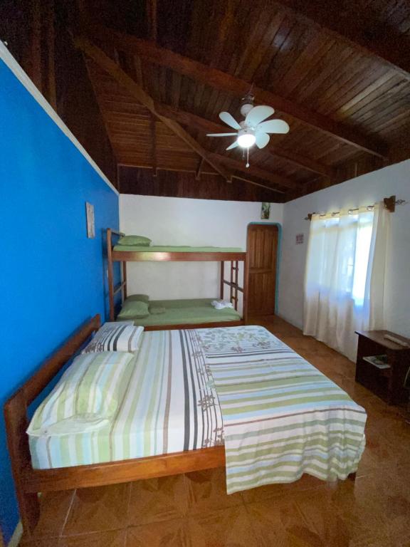 a bedroom with a bed with a ceiling fan at Cabina 1 Sweet Gulf in Puerto Jiménez