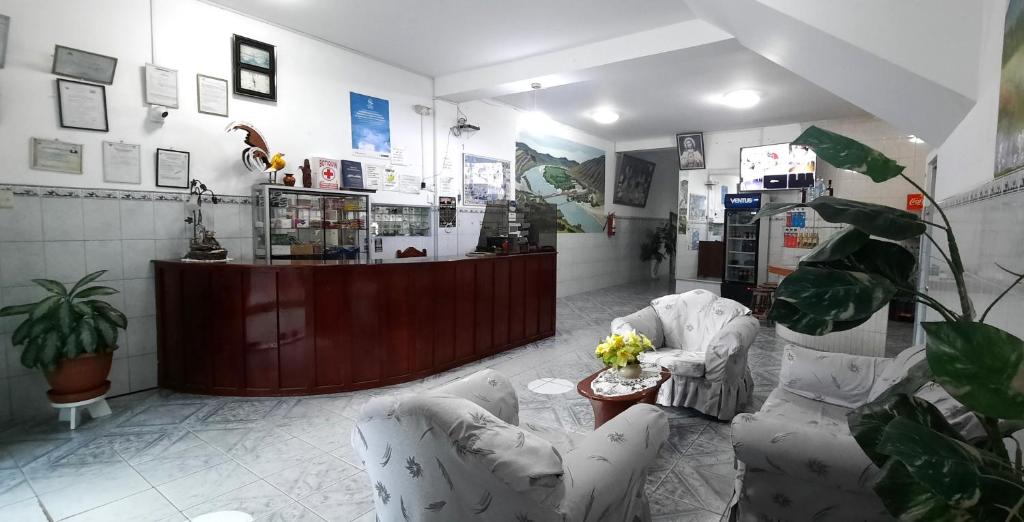 a room with two chairs and a counter in a store at Hostal Las Palmeras in Jaén