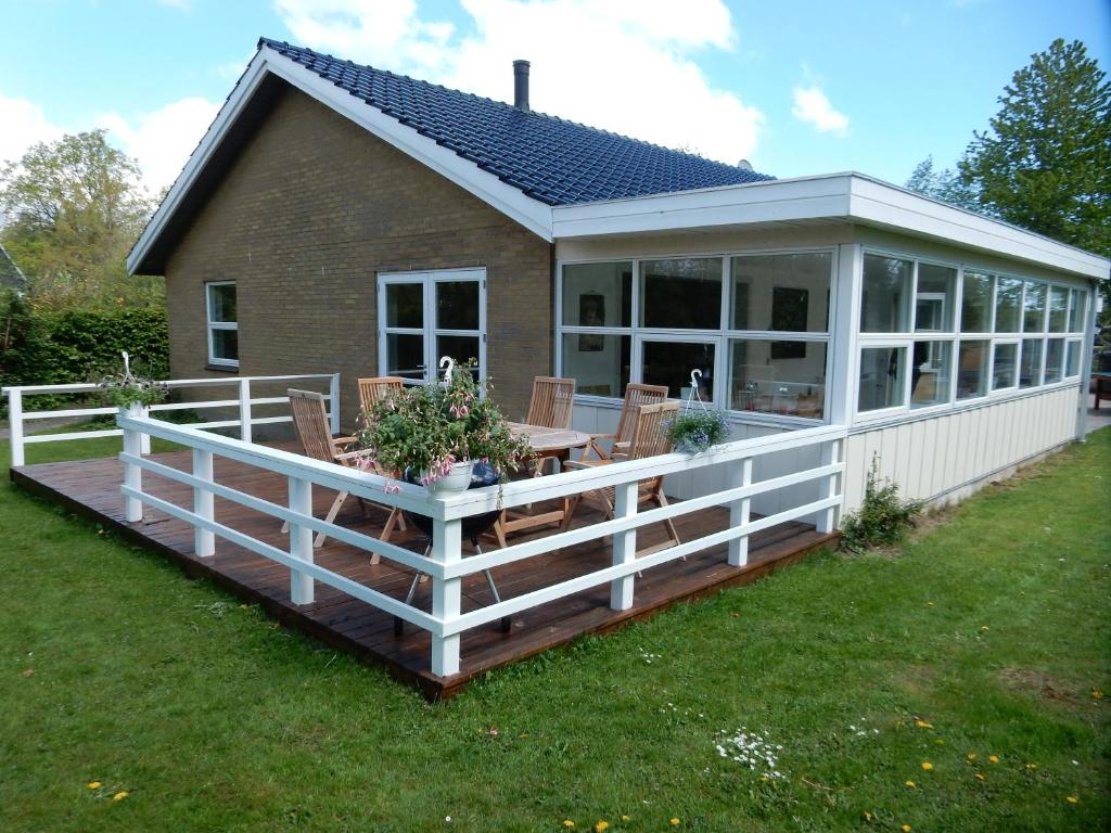 un porche cubierto con mesa y sillas en Kummelefort, en Kruså