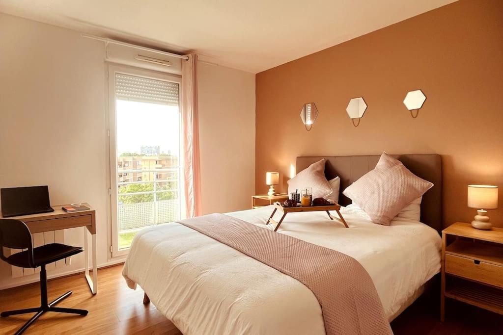 een slaapkamer met een bed, een bureau en een raam bij Penthouse de standing: Vue paris- 10min de l'aéroport Orly - Parking gratuit in Orly