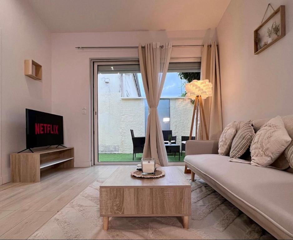 ein Wohnzimmer mit einem Sofa und einem Tisch in der Unterkunft Superbe maison de ville proche Paris in Sannois