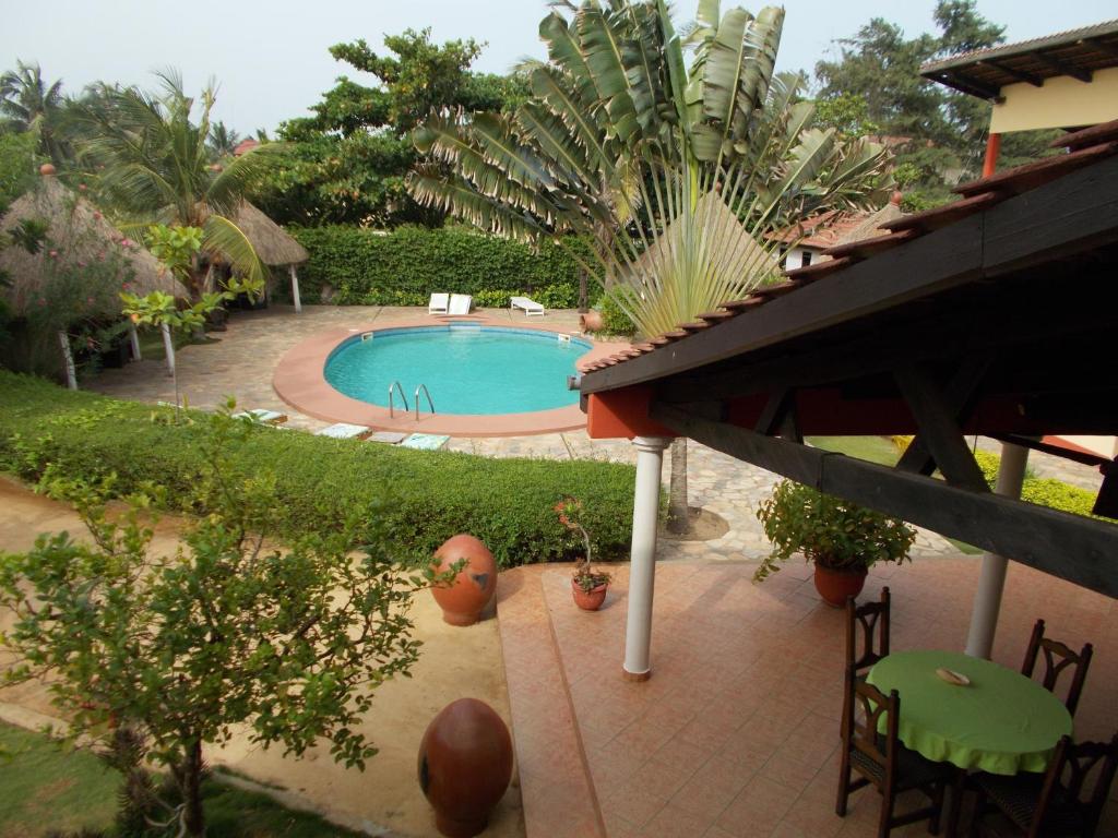 vista para uma piscina num jardim em Hôtel Alizé Plage em Baguida