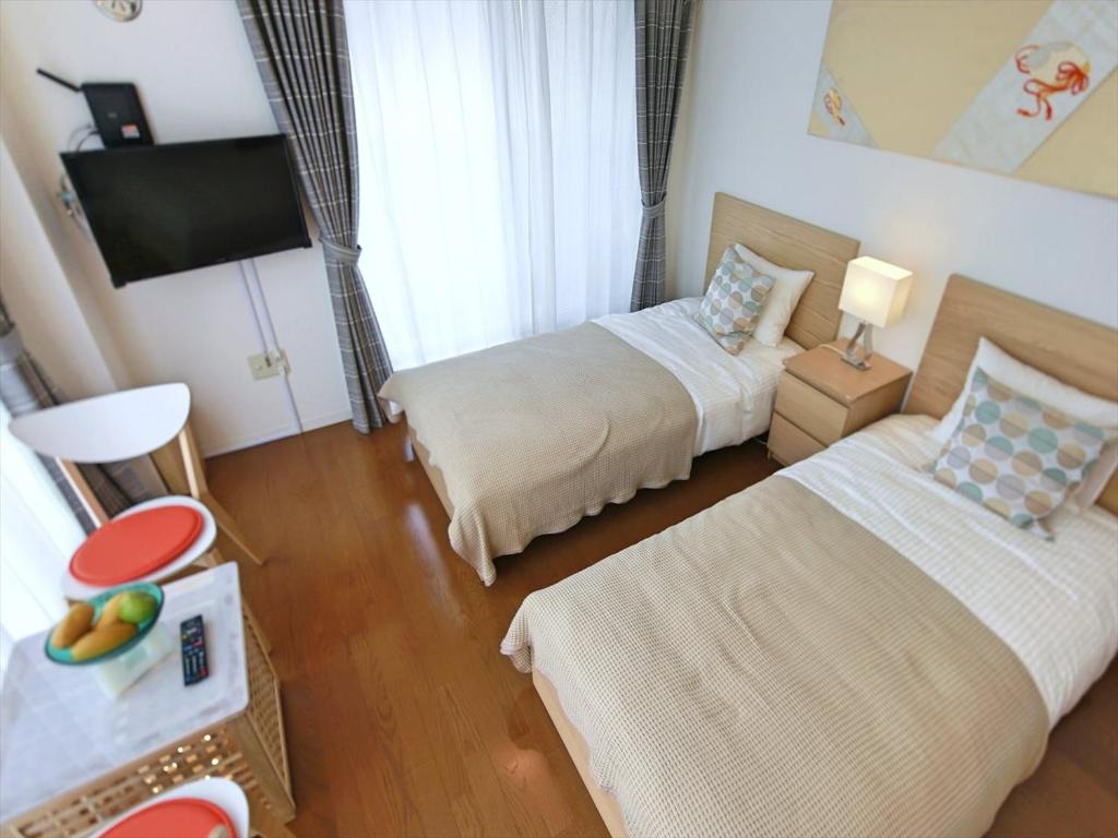 pokój hotelowy z 2 łóżkami i telewizorem w obiekcie Numero Uno Tokyo w Tokio