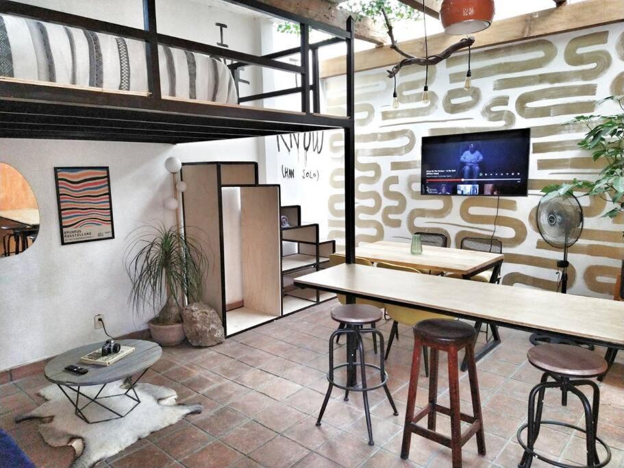 Habitación con mesa, sillas y TV. en Loft céntrico con diseño único, en Tulancingo