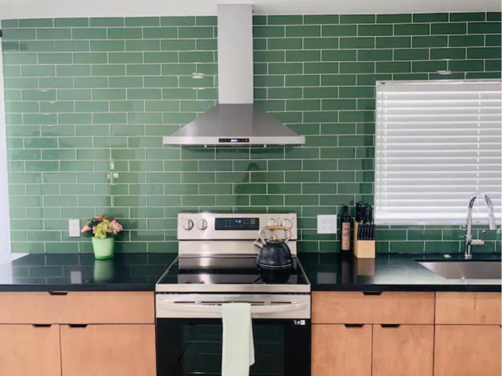uma cozinha verde com um fogão e um lavatório em Modern + Midcentury House in B Bar H Ranch em Desert Hot Springs