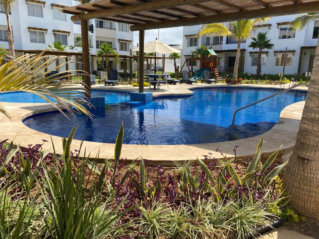 a swimming pool in a resort with trees and plants at Nuevo Departamento con Excelente Ubicación y Muy Bonita Alberca - Residencial Almarena II in Mazatlán