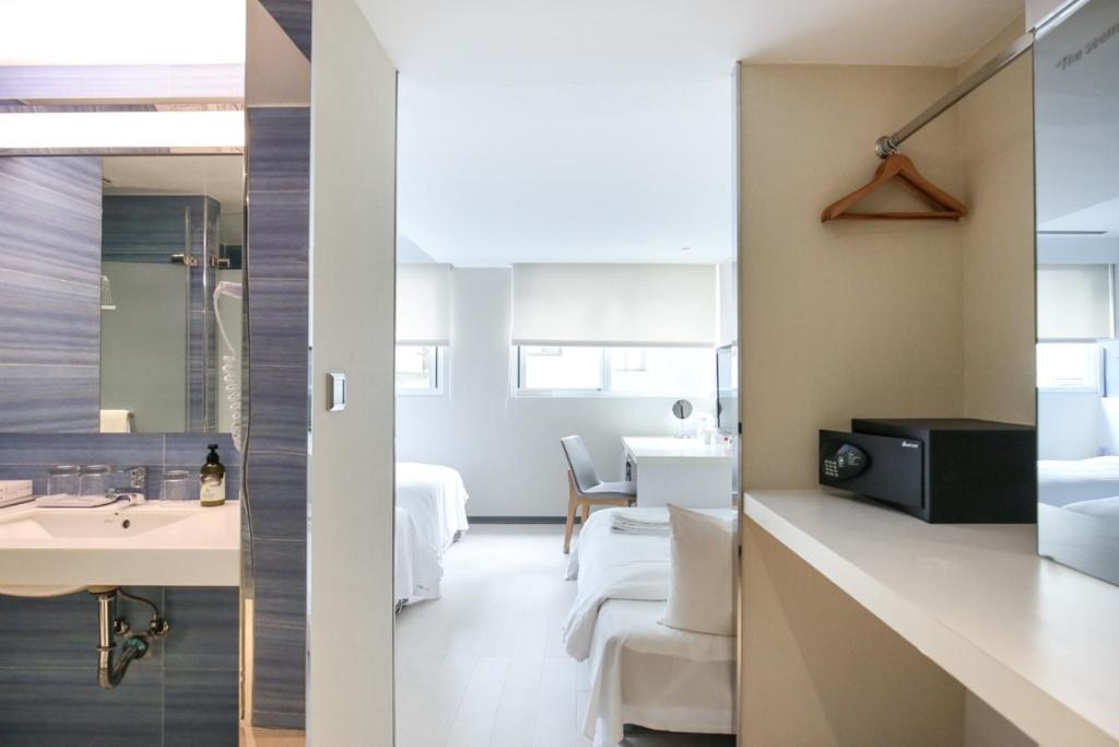 a hotel room with a sink and a bathroom at Dandy Hotel - Tianmu Branch in Taipei