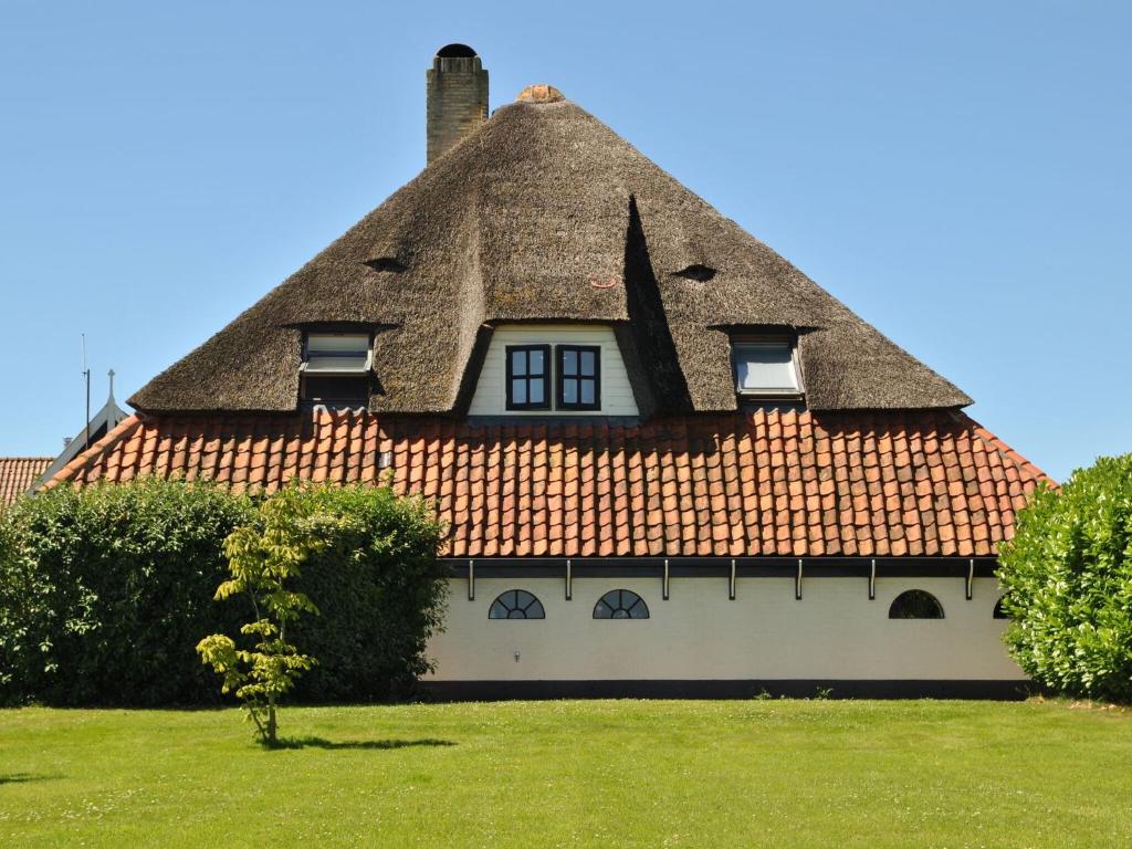 dom z dachem krytym strzechą w obiekcie Lovely Holiday Home in Texel near Sea w mieście Oost