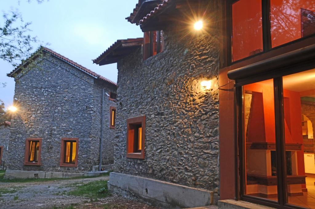 a stone building with windows and lights on it at Giusvalla Forest Village in Dego