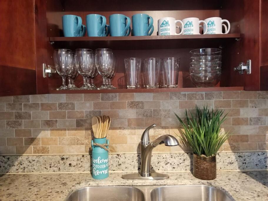 a kitchen counter with a sink and glasses on a shelf at My Nautical Paradise in Miami in Miami