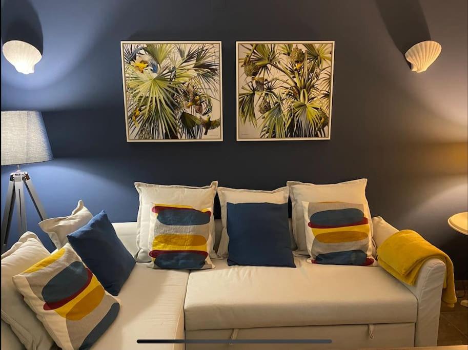 - un canapé blanc avec des oreillers dans l'établissement Casa Buccaneer, 2 Bedroom Garden Apartment in Praia da Luz, à Luz