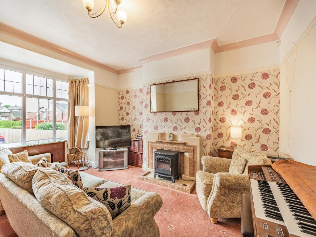 a living room with a couch and a fireplace at 15 Elms Road in Bare