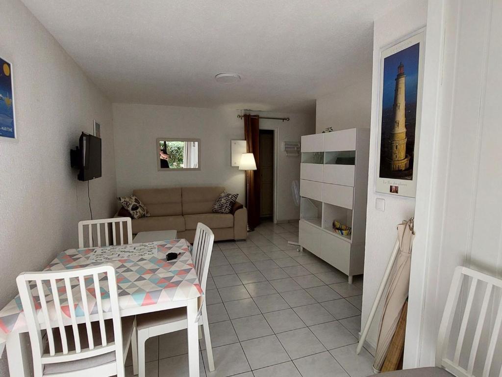 une cuisine et un salon avec une table et des chaises dans l'établissement Appartement 2 pièces avec jardinet, proche plage et forêt à Saint-Georges-de-Didonne - FR-1-550-64, à Saint-Georges-de-Didonne