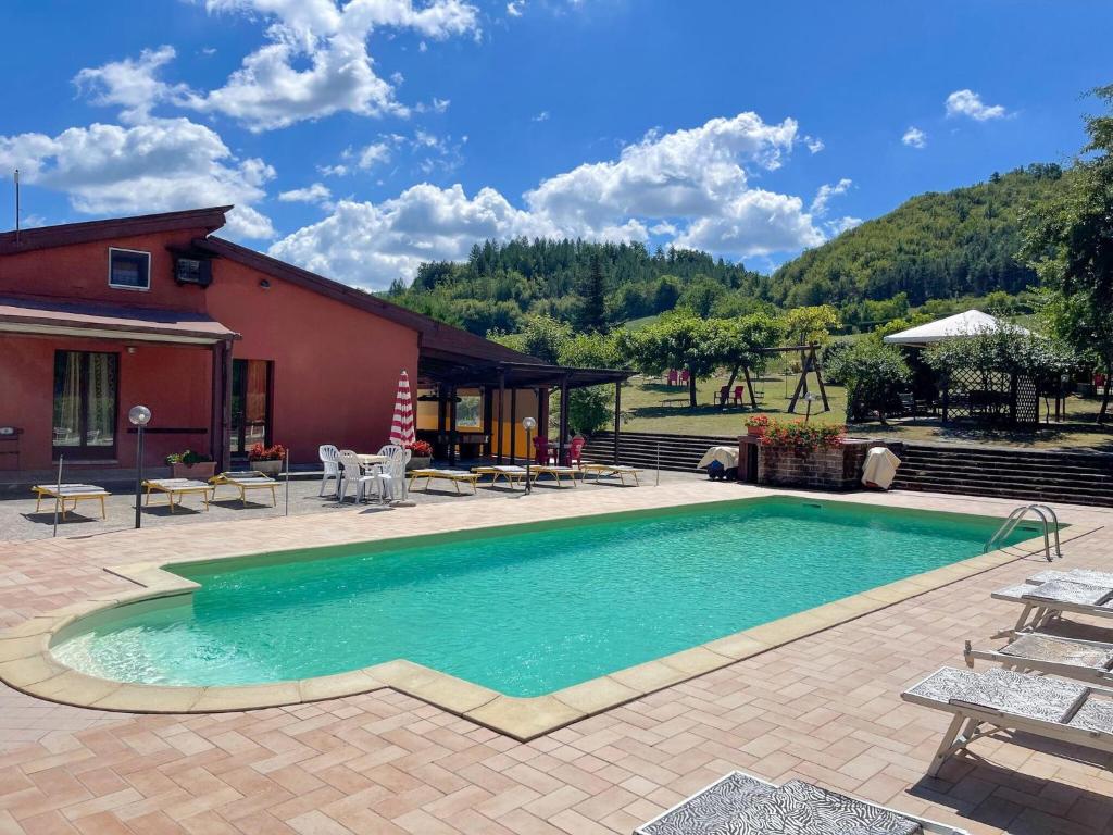 een zwembad met een patio en een huis bij Welcoming holiday home in Urbania with pool in Urbania