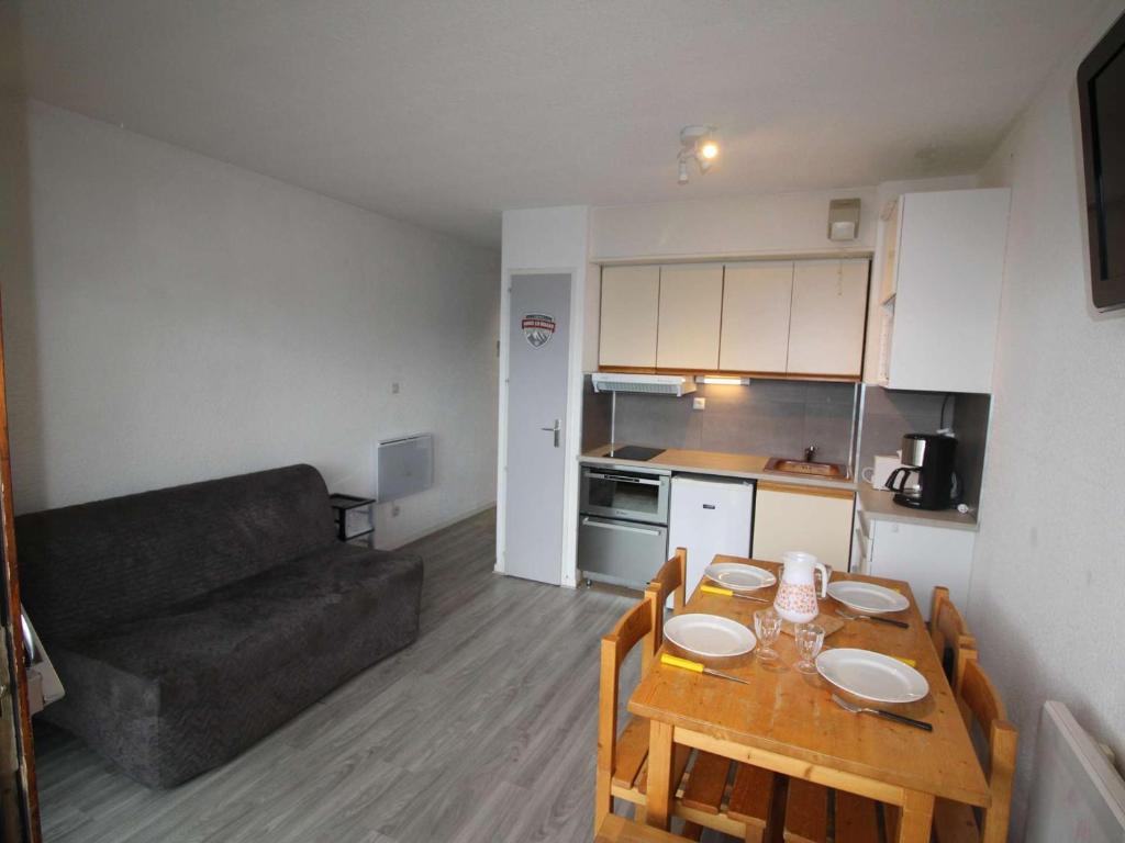 Ce petit appartement comprend une table et un canapé. dans l'établissement Studio cabine fermée 4 pers au pied des pistes avec parking - Auris en Oisans - FR-1-297-334, à Auris