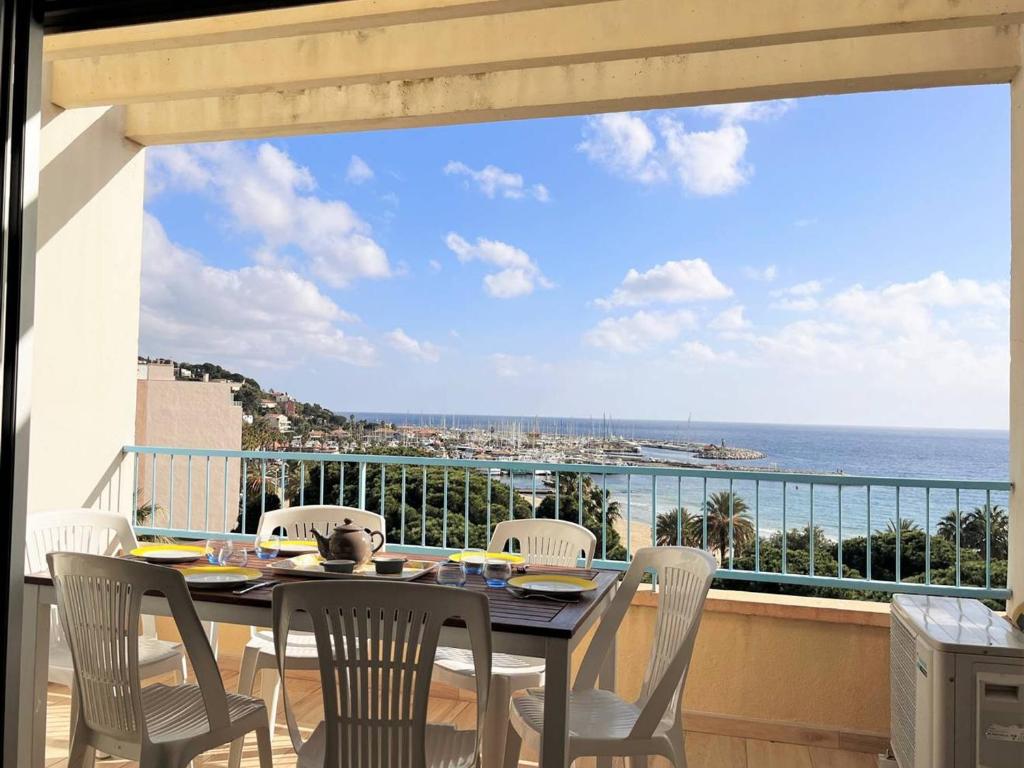 une table et des chaises sur un balcon avec vue sur l'océan dans l'établissement Appartement climatisé 3 pièces, 6 couchages - Face à la plage - Le Lavandou - FR-1-251-510, au Lavandou