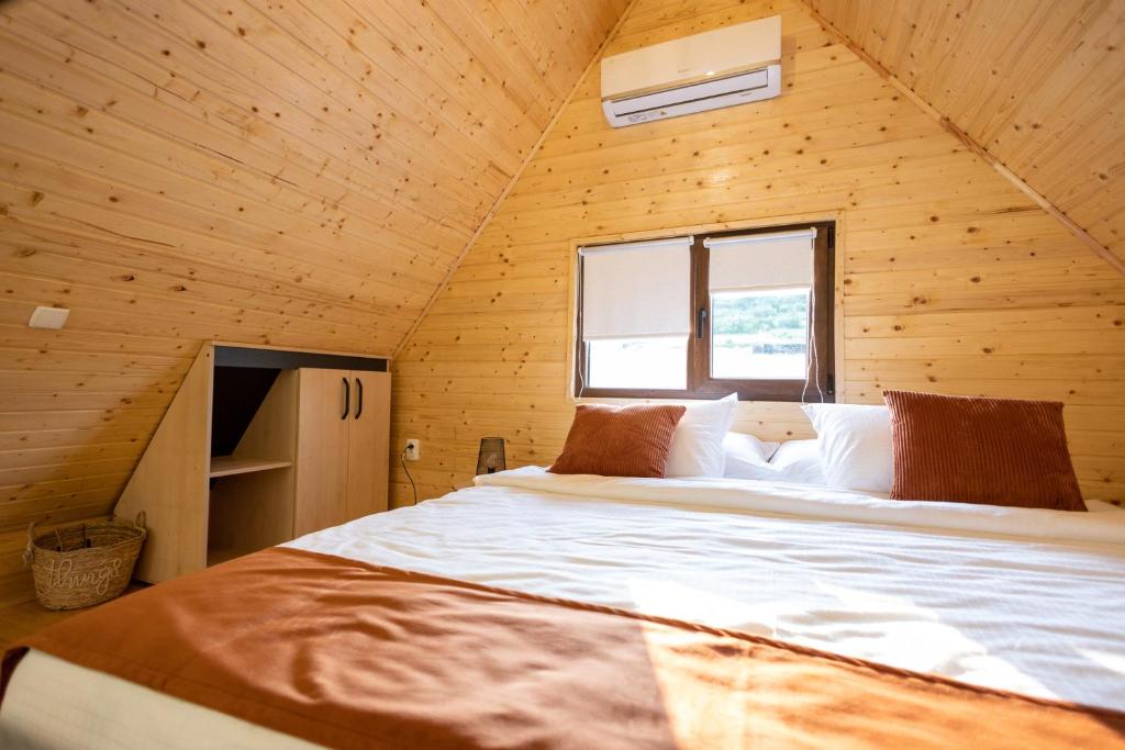 sypialnia z dużym łóżkiem w drewnianym pokoju w obiekcie MILLAR's w mieście Sovata