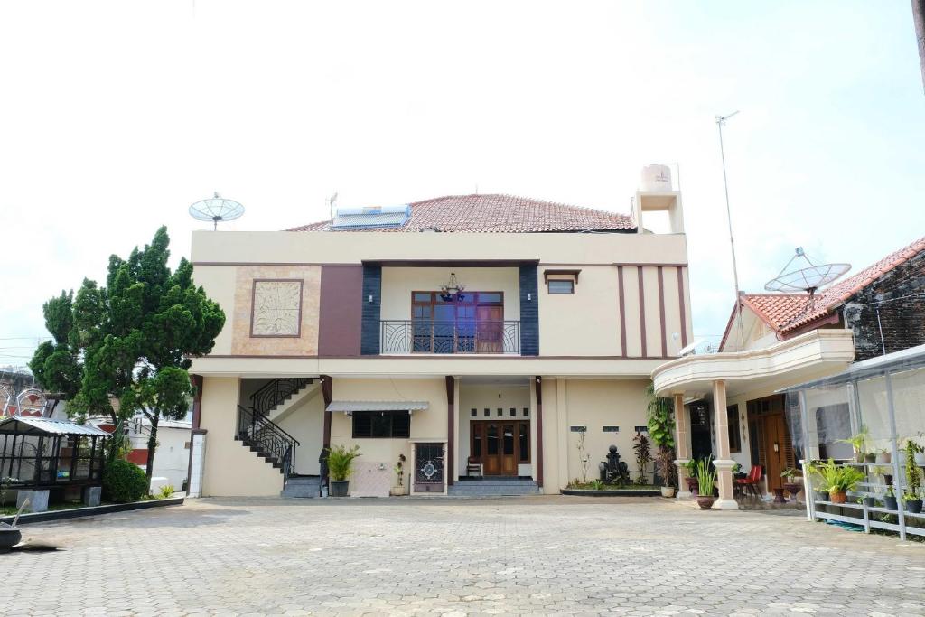 a large white house with a balcony on a street at Homestay Griya Kinasih Syariah Pati Mitra RedDoorz in Pati