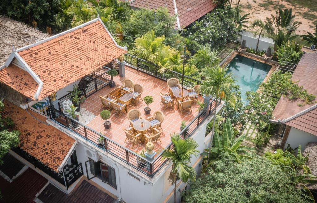 een uitzicht op een huis met een patio en een zwembad bij The Botanic Garden Hotel in Siem Reap