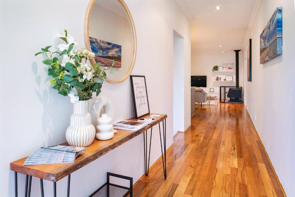 a living room with a table and a vase with flowers at Kalima Retreat - The Ultimate Uncomplicated & Relaxing Holiday! in Dunsborough