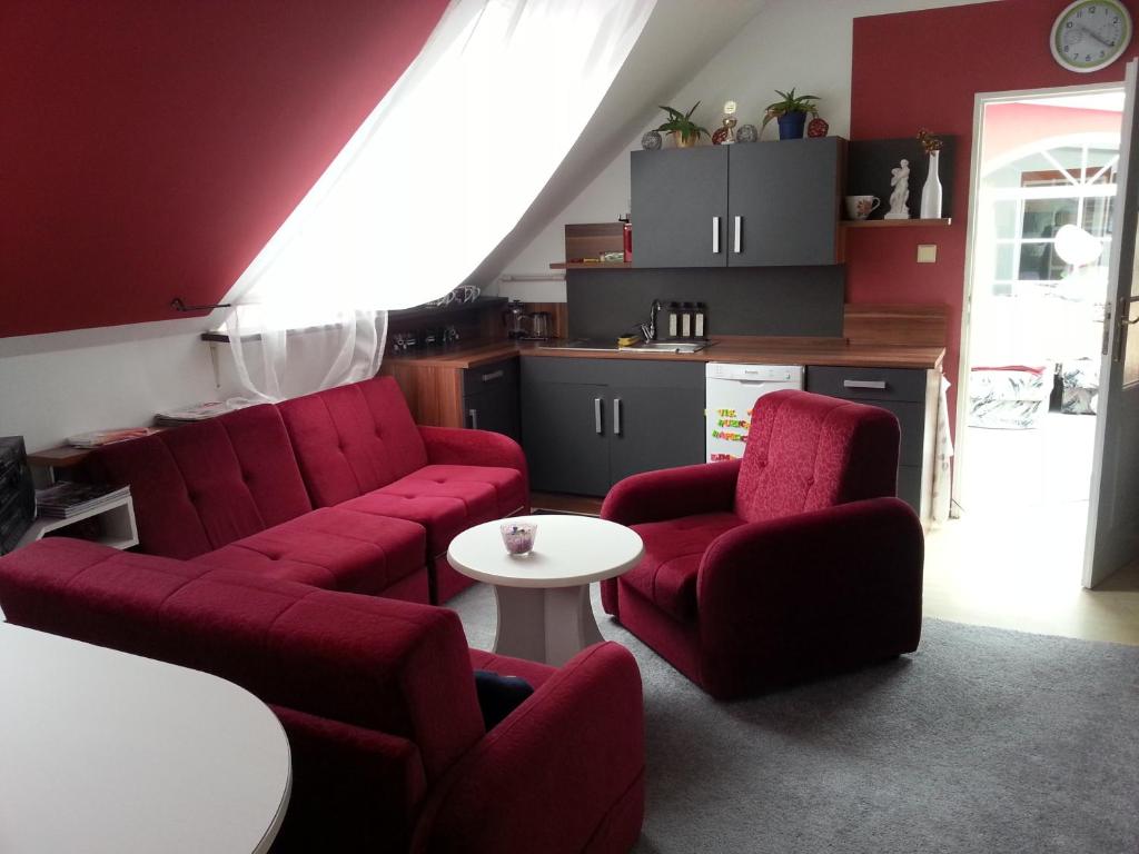 a living room with red chairs and a table at Homestay Kuchařovice in Kuchařovice