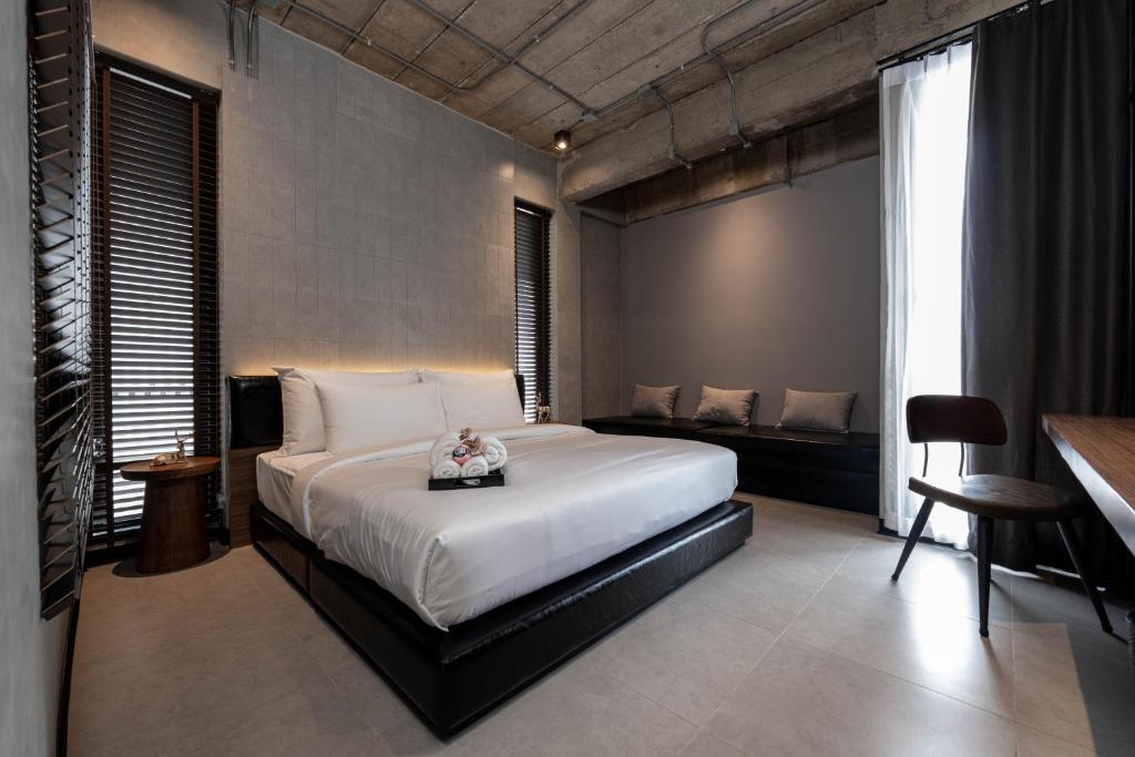 a bedroom with a large white bed and a couch at EX2 Hotel in Ban Bang Khen (1)