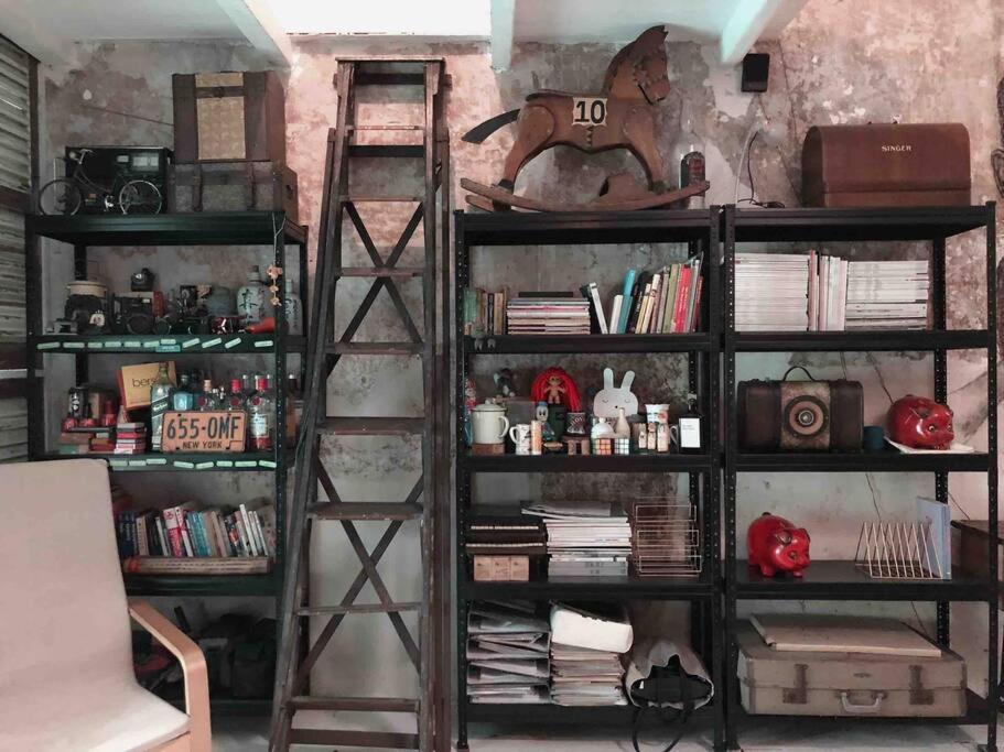 ein Bücherregal gefüllt mit Büchern in einem Raum in der Unterkunft Artist Heritage Penang UNESCO Home (Lebuh Armenian) in George Town