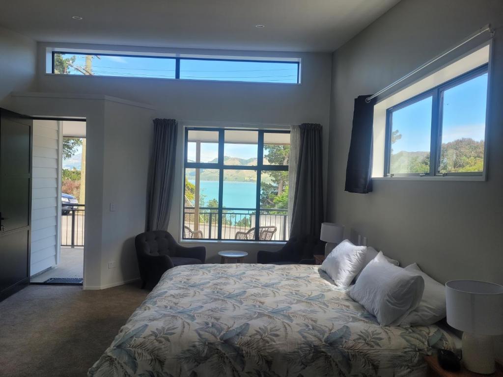 a bedroom with a bed with a view of the ocean at Taimana Boutique Motel in Diamond Harbour