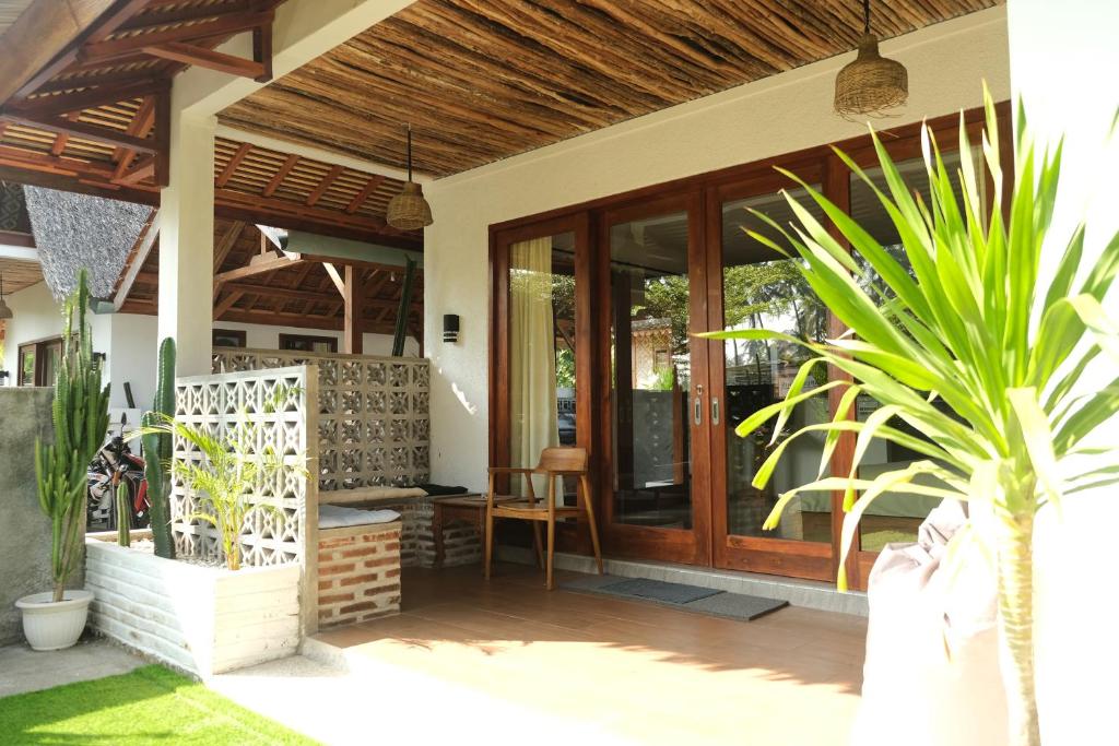 a house with a wooden door and a plant at Hideaway Batukaras in Pangandaran