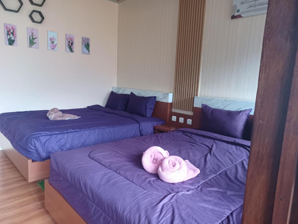 een kamer met 2 bedden en roze handdoeken bij Villa sunset 