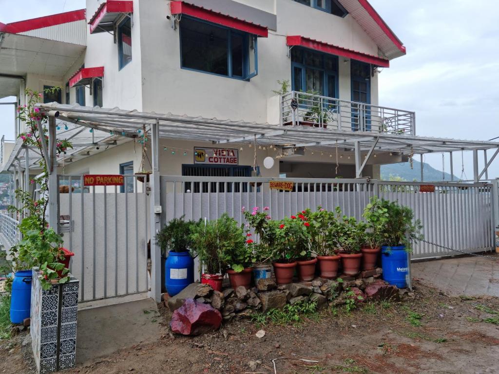 une maison avec des plantes en pot devant une clôture dans l'établissement Vista Solan, à Solan