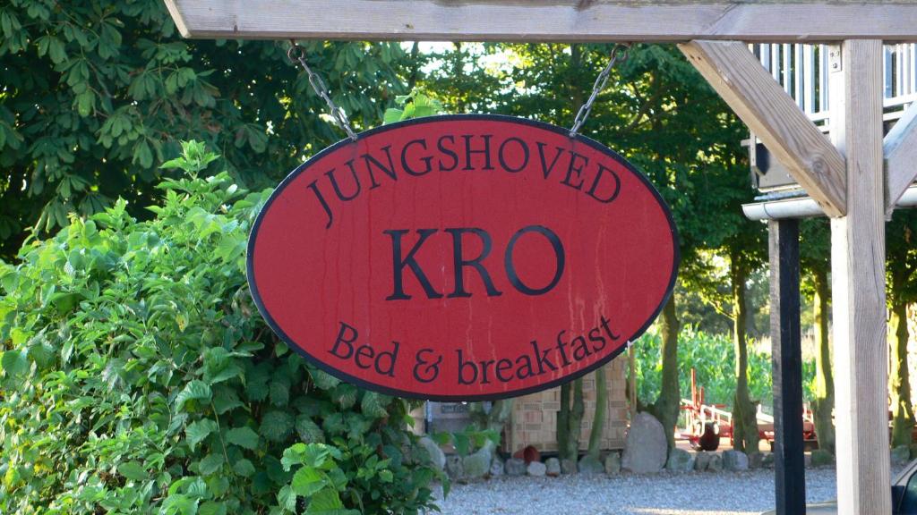 Un panneau rouge qui lit le kro bed and breakfast dans l'établissement Jungshoved Kro B&B, à Præstø