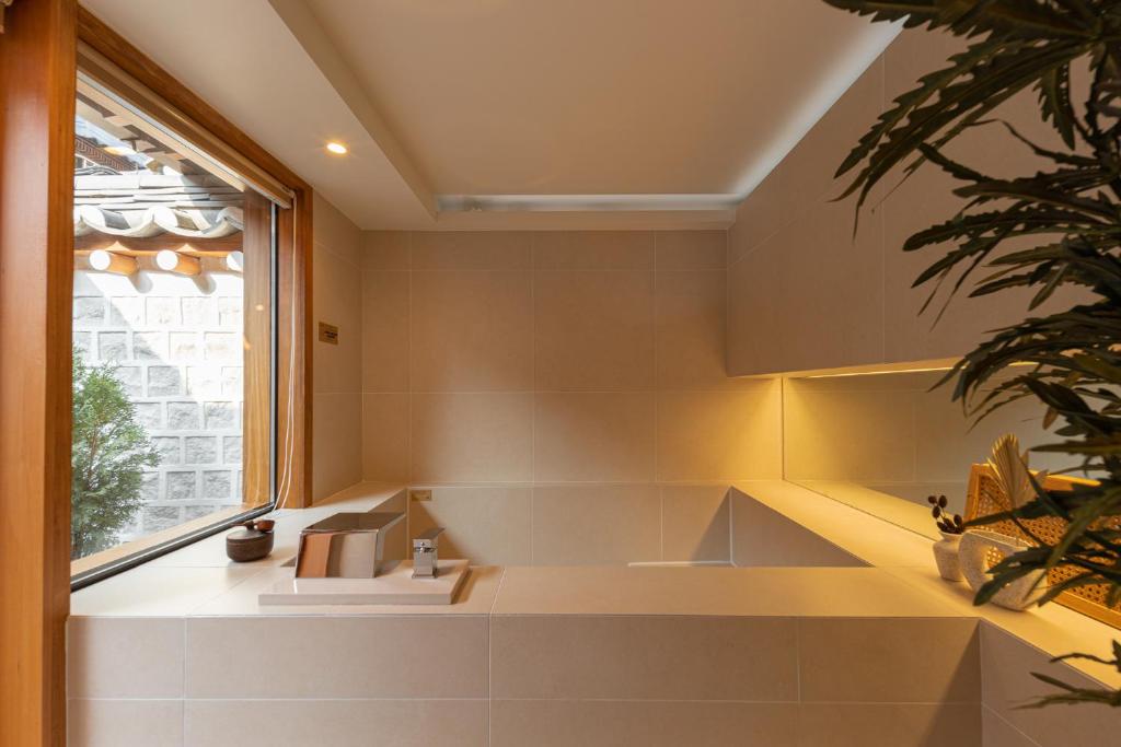 a bathroom with a large tub and a window at Luxury hanok with private bathtub - SW12 in Seoul