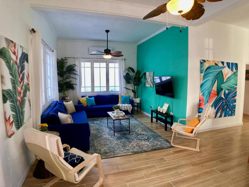 sala de estar con sofá azul y sillas en Casa Blanca Miramar en San Juan