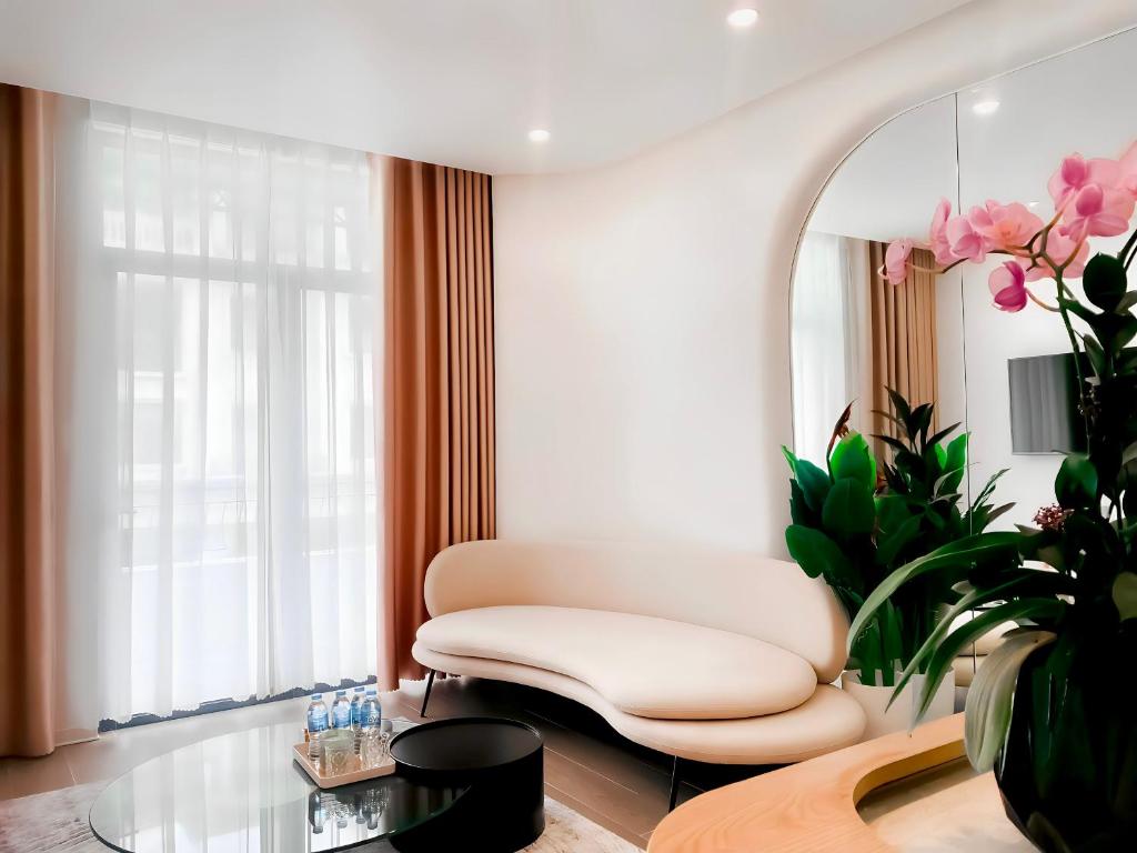 ein Wohnzimmer mit einem weißen Stuhl und einem Spiegel in der Unterkunft Metahome Apartment HOT Độc Đáo Nhất Vinhome Marina in Haiphong