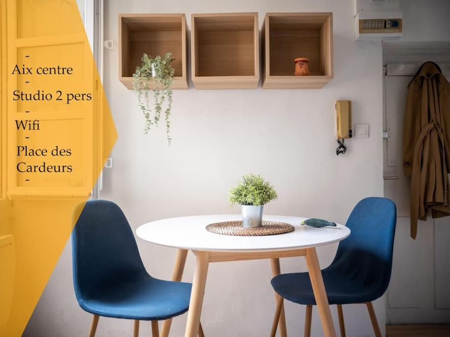 una mesa y dos sillas azules en una habitación en Studio tout équipé au coeur de Aix en Provence, en Aix-en-Provence