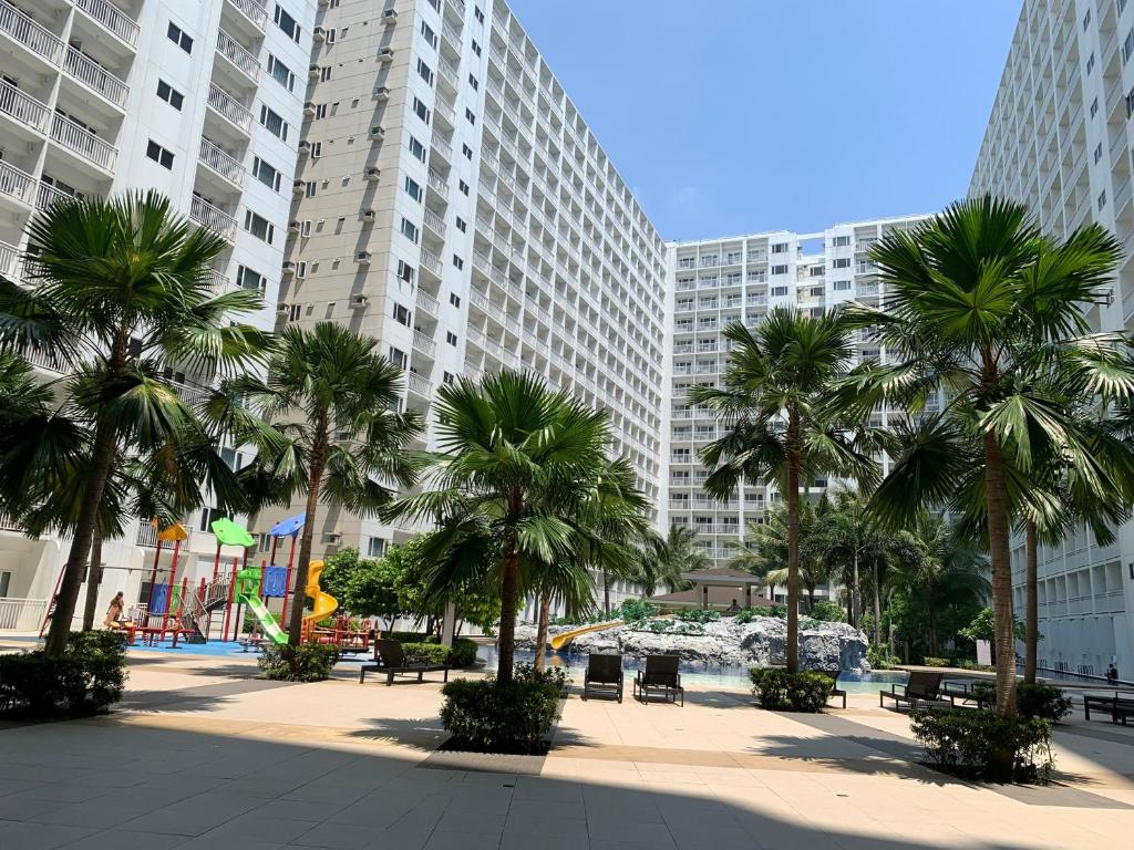 a park with palm trees and tall buildings at SMDC Shore Residences 1 Mall of Asia Complex Pasay in Manila