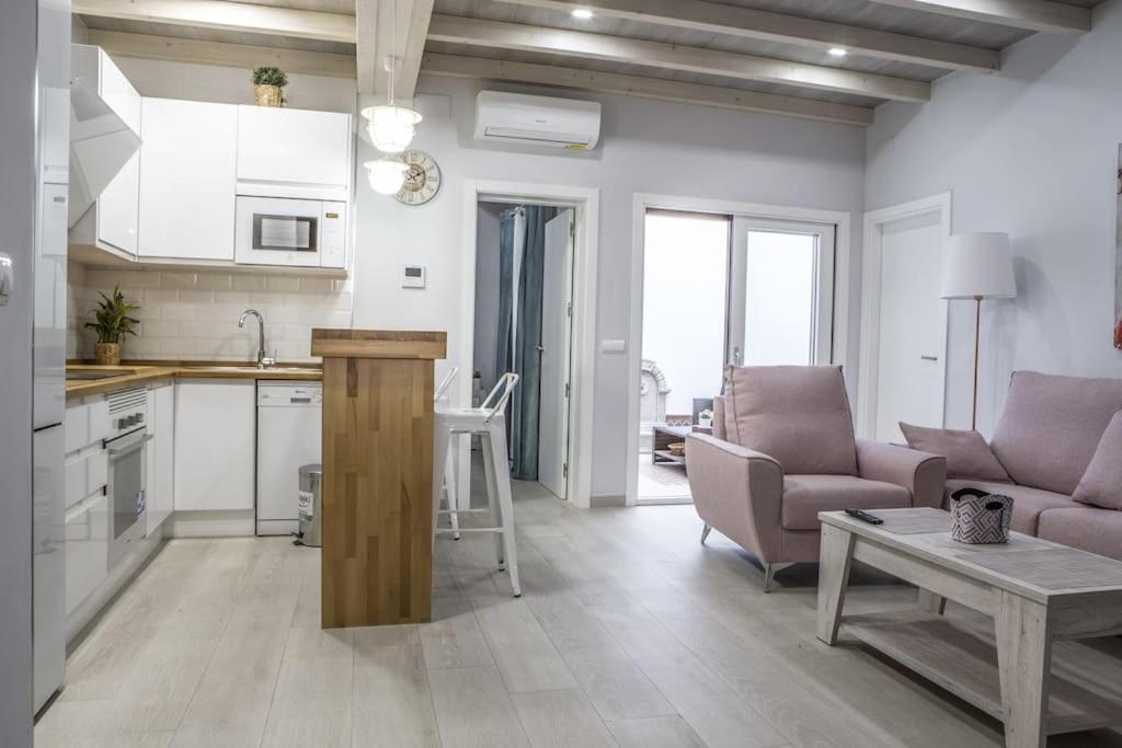 een keuken en een woonkamer met een bank en een tafel bij Elegante y acogedor. Buena ubicación in Osuna