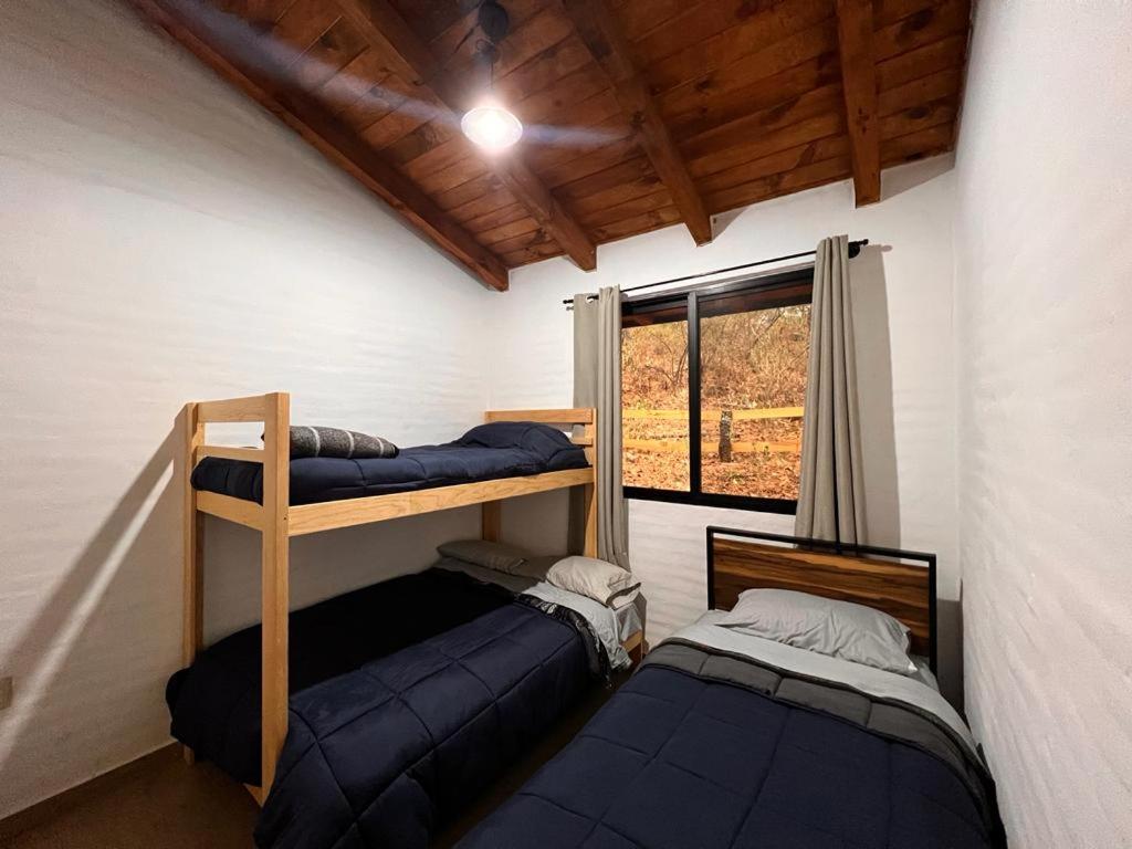 two bunk beds in a room with a window at Cabaña El Encanto in Mazamitla
