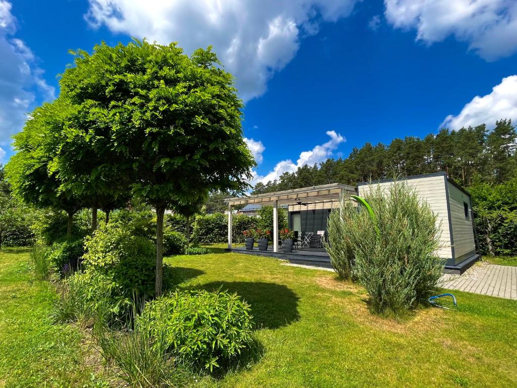 a house in a garden with a tree at Eden House in Druskininkai