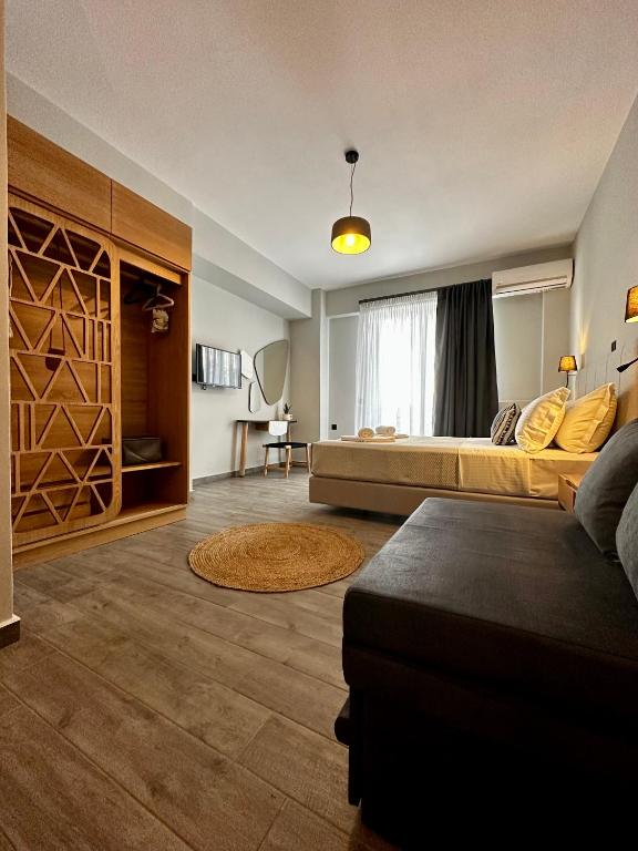 a large room with a bed and a couch at Thea comfy living in Nea Vrasna